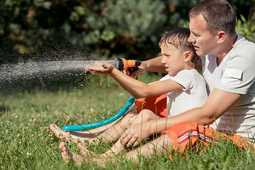 Image showing Happy father and son playing in the garden at the day time. 