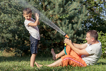 Image showing Happy father and son playing in the garden at the day time.