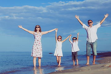 Image showing Happy family walking on the beach at the day time.