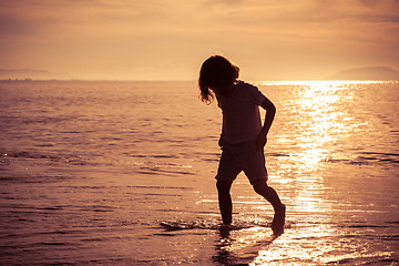 Image showing Happy little boy standing on the beach 