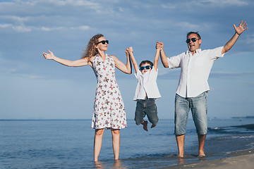 Image showing Happy family walking on the beach at the day time.