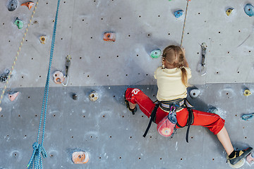 Image showing little girl climbing a rock wall indoor