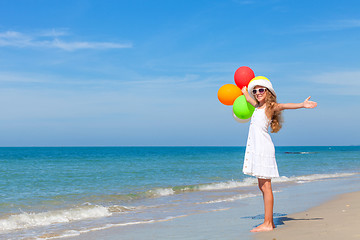 Image showing Teen girl with balloons standing on the beach