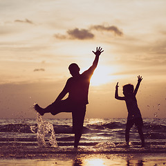 Image showing Father and son playing in the park at the sunset time.