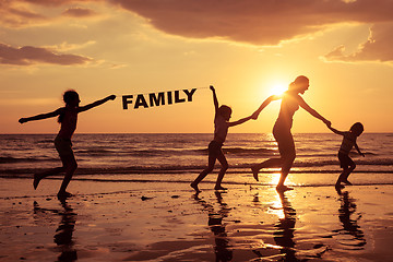 Image showing Happy children playing on the beach at the sunset time.