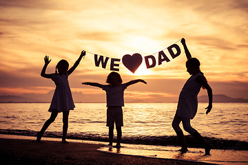 Image showing Happy children playing on the beach at the sunset time. 