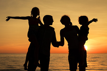 Image showing Silhouette of happy family who playing on the beach at the sunse