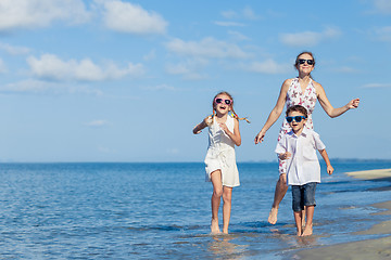 Image showing Mother and children playing on the beach at the day time.