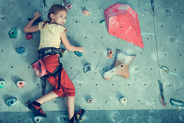 Image showing little girl climbing a rock wall indoor