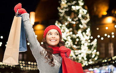 Image showing happy woman with shopping bags over christmas tree