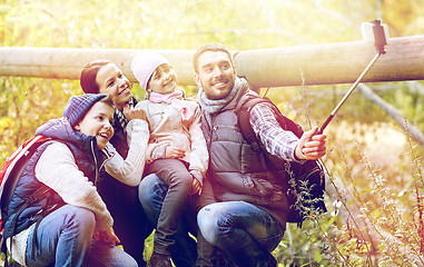 Image showing happy family with smartphone selfie stick in woods