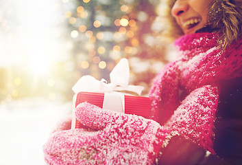 Image showing close up of woman with christmas gift outdoors