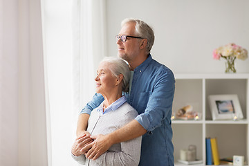 Image showing happy senior couple looking through window at home