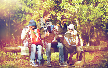Image showing happy family with backpacks and thermos at camp