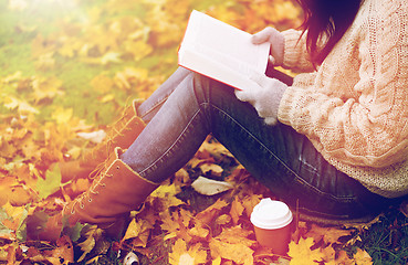 Image showing woman with book drinking coffee in autumn park