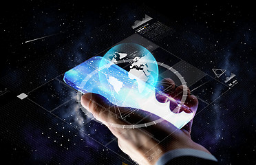 Image showing hand with smartphone and earth projection