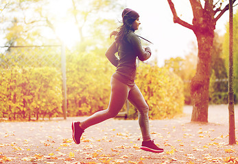 Image showing close up of young woman running in autumn park