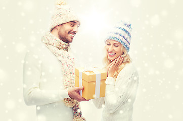 Image showing smiling couple in winter clothes with gift box