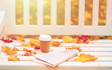 Image showing newspaper and coffee cup on bench in autumn park