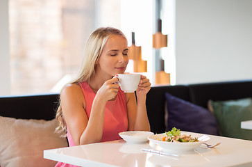 Image showing woman eating and drinking coffee at restaurant