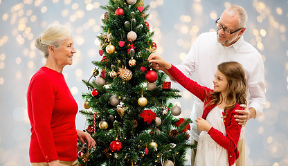 Image showing grandparents and granddaughter at christmas tree