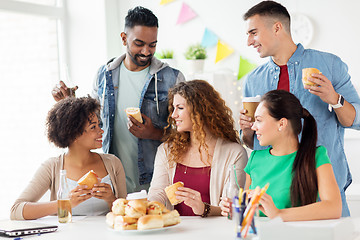 Image showing happy friends or team eating at office party