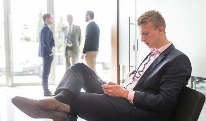 Image showing Businessman using smart phone while sitting in waiting room.