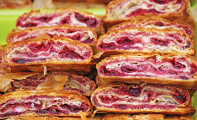 Image showing Sliced homemade strudel with cherry in streat market