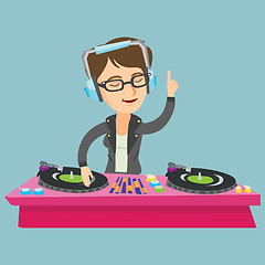 Image showing Young caucasian DJ mixing music on turntables.