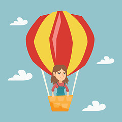 Image showing Young caucasian woman flying in hot air balloon.