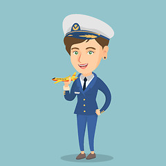 Image showing Cheerful airline pilot with the model of airplane.