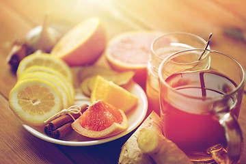 Image showing ginger tea with honey, citrus and garlic on wood