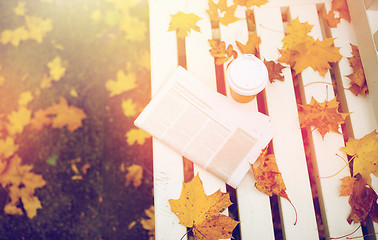 Image showing newspaper and coffee cup on bench in autumn park