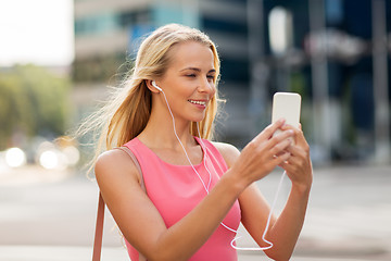 Image showing happy young woman with smartphone and earphones