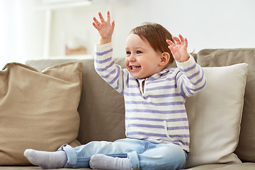 Image showing happy smiling baby girl sitting on sofa at home