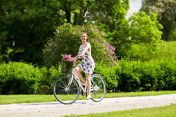 Image showing happy woman riding fixie bicycle in summer park