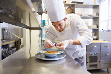 Image showing happy male chef cooking food at restaurant kitchen