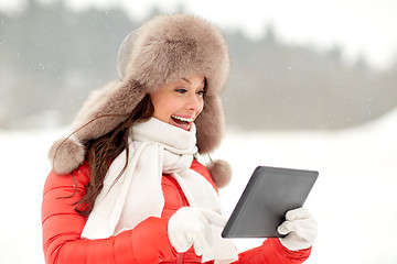 Image showing woman in winter fur hat with tablet pc outdoors