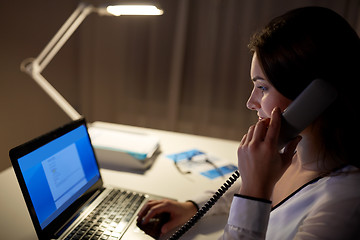 Image showing woman with laptop calling on phone at night office