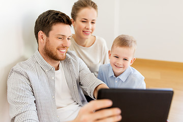 Image showing happy family with tablet pc moving to new home