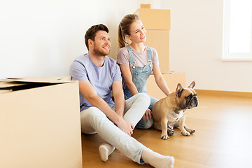 Image showing happy couple with boxes and dog moving to new home