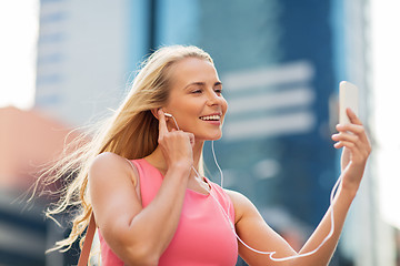 Image showing happy young woman with smartphone and earphones