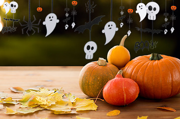 Image showing pumpkins with autumn leaves and halloween garland