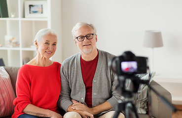 Image showing happy senior couple with camera recording video