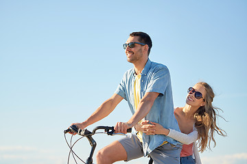 Image showing happy couple riding bicycle together in summer