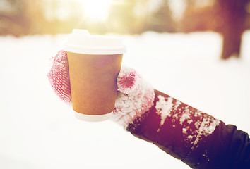 Image showing close up of hand with coffee outdoors in winter