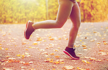 Image showing close up of young woman running in autumn park