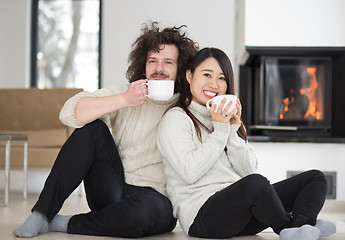 Image showing happy multiethnic couple  in front of fireplace