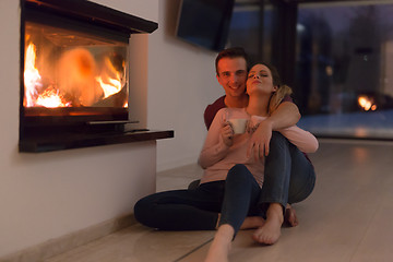 Image showing happy couple in front of fireplace