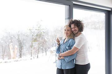 Image showing young couple enjoying morning coffee by the window